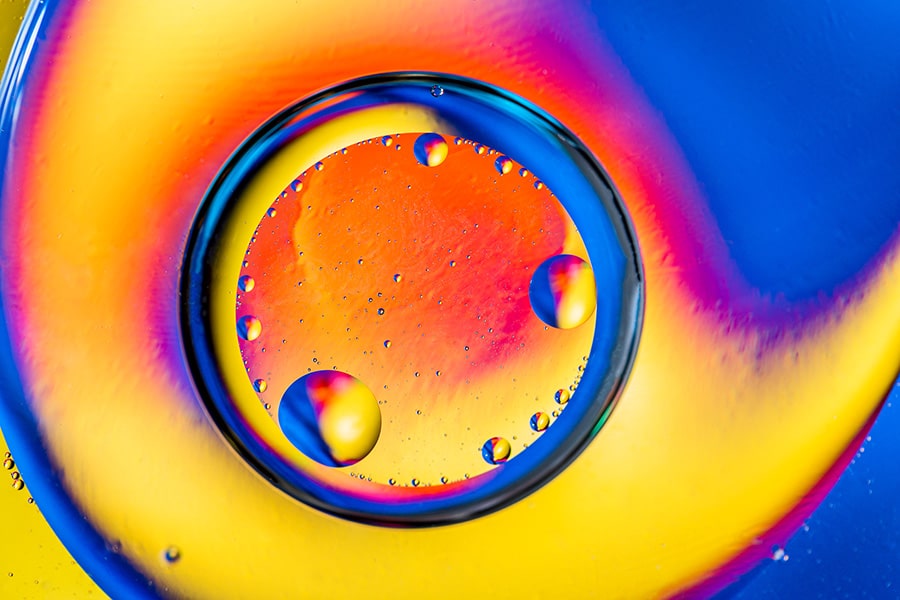 Abstract background with colorful gradient colors. Oil drops in water abstract psychedelic pattern image. Blue orange yellow colored abstract pattern.